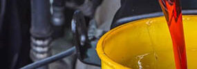 A man pours transmission fluid into his engine